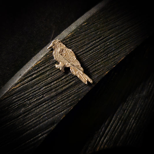 Sterling silver bird-shaped decorative item on a dark wooden surface