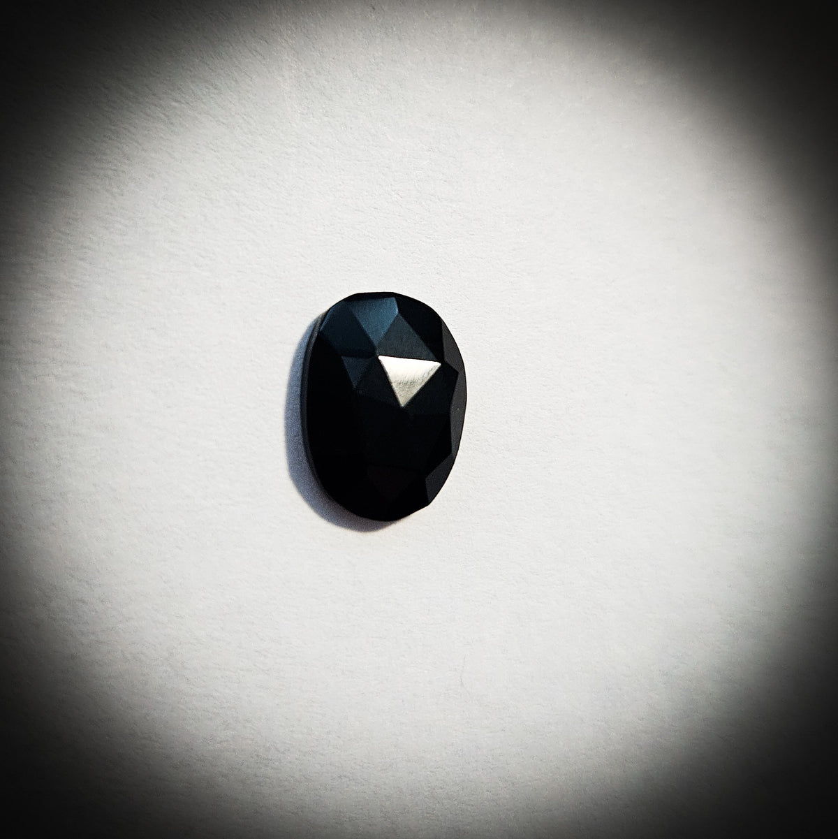 Stone option one, faceted black gemstone on a light gray background 