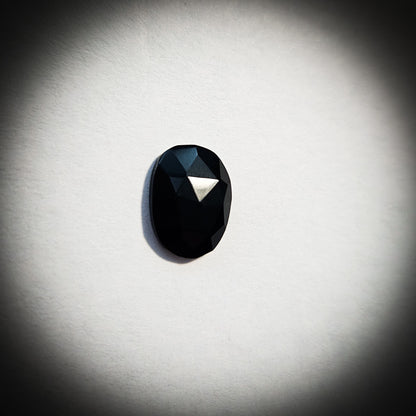 Stone option one, faceted black gemstone on a light gray background 