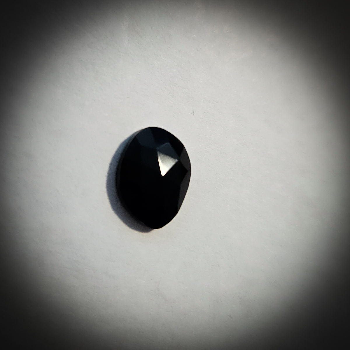 Stone option two, faceted black gemstone on a light gray background 