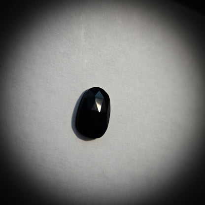 Stone option three, faceted black gemstone on a light gray background 
