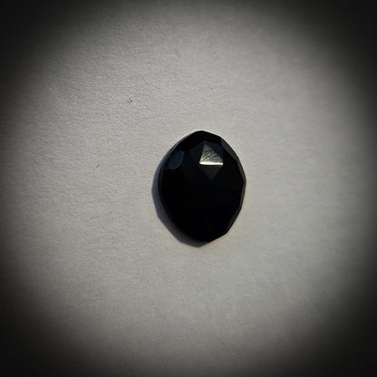 Stone option four, faceted black gemstone on a light gray background 